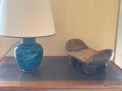un vase bleu et un banc en bois posés sur une table