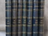 six vieux livres alignés sur une surface blanche