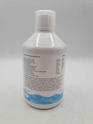 une bouteille de liquide posée sur une table blanche
