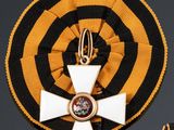 a cross and a medal on a black and yellow ribbon