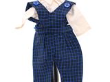 une salopette à carreaux bleus et noirs, avec une chemise blanche et un nœud papillon