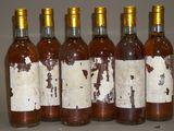 six bouteilles de vin sont alignées sur une table