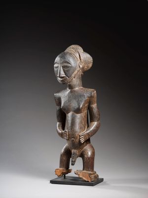 une statue en bois représentant une femme tenant un bébé dans ses bras