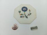 un petit morceau de marbre sur lequel est représentée une fleur