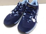 blue and white sneakers on a white surface with a wall in the background