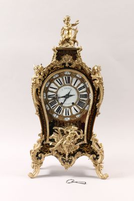 a gold clock with roman numerals on it
