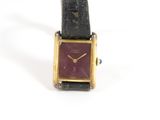 une photo d'une montre-bracelet posée sur une surface blanche