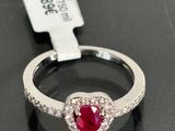 an image of a heart shaped ruby and diamond ring on a black surface