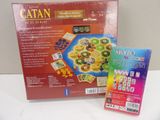 a box of catan on the table next to a card game