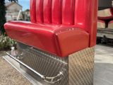 a red bench that is sitting on a metal stand