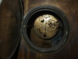 a clock that is sitting inside of a metal container