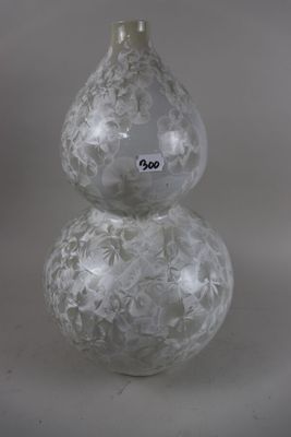 a glass vase that has a white design on it