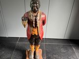 une figurine représentant un homme debout sur une balance