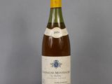 an old bottle of wine sitting on top of a glass table