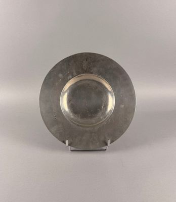 a silver plate on a stand on a white surface