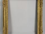 a gold picture frame with a white wall behind it