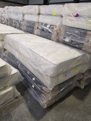 a lot of mattresses stacked on top of each other in a warehouse