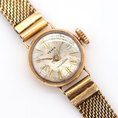 a close up of a gold wrist watch with roman numerals