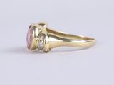 a gold ring with a pink stone and two diamonds