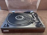 un gros plan d'un tourne-disque posé sur une table, avec son étui