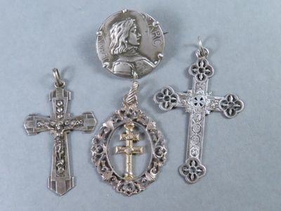 trois croix en argent et une médaille en argent sur fond bleu