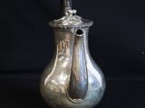 a silver vase with a handle on a black background