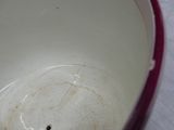 a white bowl with a red rim sitting on a table