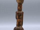 an old wooden figurine with a bird on it ' s head