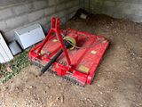 une machine rouge qui est à l'arrêt dans la poussière
