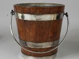 a wooden bucket with a metal handle on a table