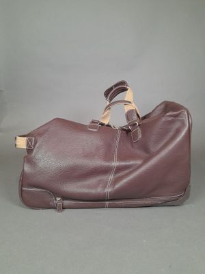 brown leather duffel bag with strap and handles on grey background