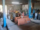 an image of a garage with a tractor and other equipment