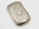 an antique silver cigarette case with a monogram on the front