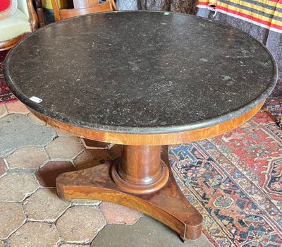 a table with a black marble top sitting on a rug