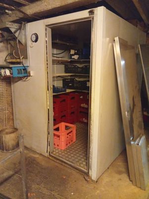 a white refrigerator in a room with a lot of shelves