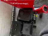 un chariot rouge rempli de nourriture posé par terre