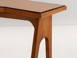 a close up of a wooden table with a glass top on a white surface