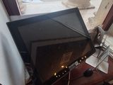 a computer monitor sitting on a desk in front of a window