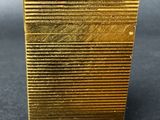 a close up of a gold plate on a black surface