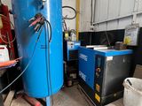 un grand réservoir bleu posé dans un garage, à côté d'autres équipements