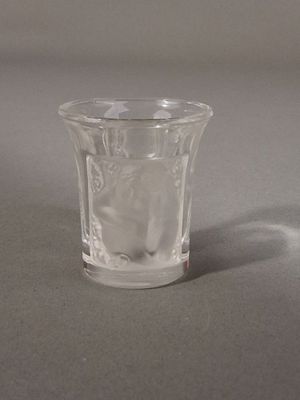 a small glass cup with ice in it sitting on a table
