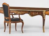 un bureau avec une chaise à côté, posé sur une surface blanche