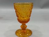 yellow glass wine goblet on a white background