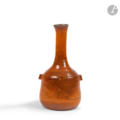 un vase brun posé sur une surface blanche