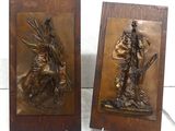 pair of bronze sculptures of a man and a woman on a horse