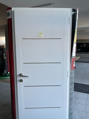 une porte blanche avec une poignée rouge dans une pièce