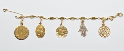 un gros plan d'un bracelet en or orné de cinq breloques