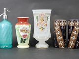 four vases and a soap dispenser on a table
