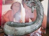 un livre posé sur une étagère à côté d'une statue de dragon