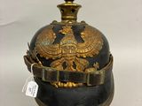 un vieux casque noir et doré orné d'un aigle doré